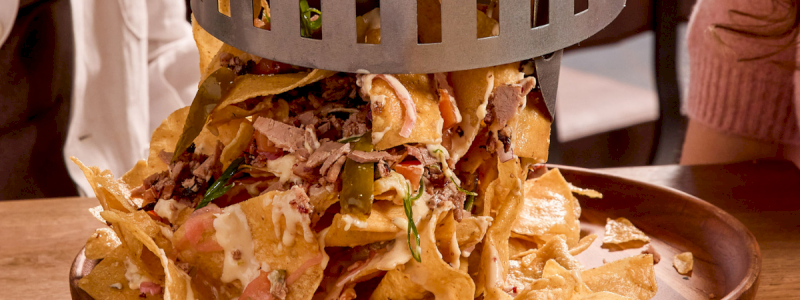 Smokehouse Trash Can Nachos - Smoked brisket, corn tortilla chips, house spice rub, queso, jalapeños, cheddar cheese, and sour cream