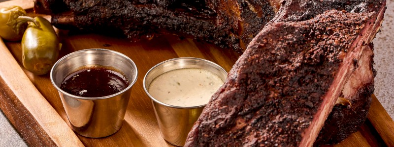 Dinosaur Bones - Smoked beef short rib bones, signature house rib, steak fries, and Smokehouse Mac