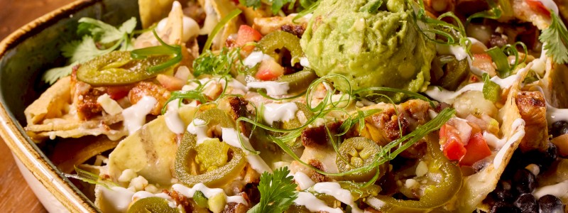 Casa Fiesta Nachos - Black beans, jalapeños, sour cream, cilantro, guacamole, queso, pico de gallo, and queso fresco. Add Chicken +4, Carne Asada +6, Shrimp +7