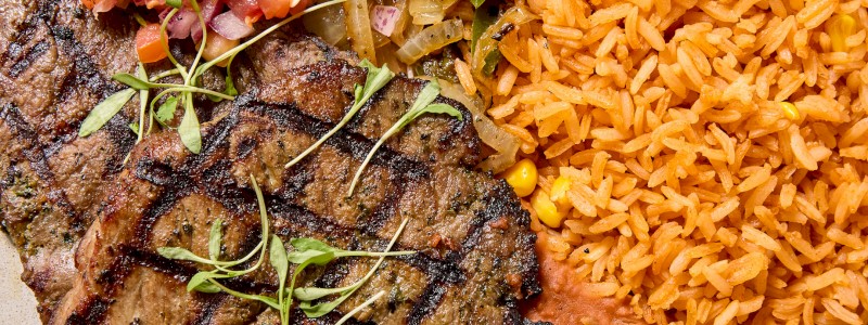 Carne Asada Grande - 6 oz Ribeye cut thin, Mexican rice, pinto & chorizo beans,
charred jalapenos, green onion, cilantro, and lime