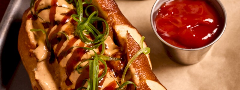 Bussin' Bratwurst - Smokehouse Social pulled pork, beer cheese, and BBQ
sauce on pretzel roll