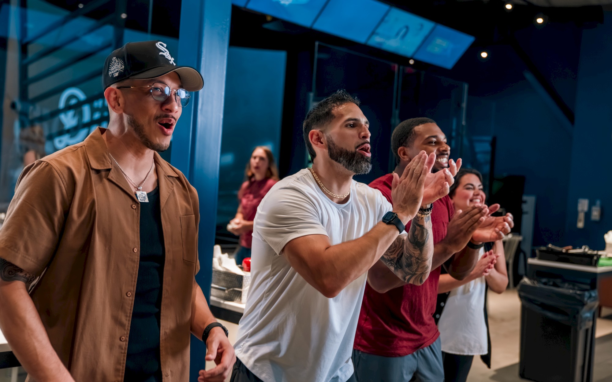 Option 2 (short / alt text) Friends play the baseball simulator at Curveball Kitchen at OKANA Resort in OKC while enjoying food and drinks from the Curveball Kitchen menu.