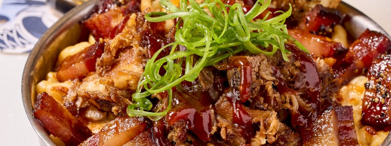 PORKY'S REVENGE MAC - Three cheese blend, pulled pork, Bullseye bacon, crispy onions, and BBQ drizzle.