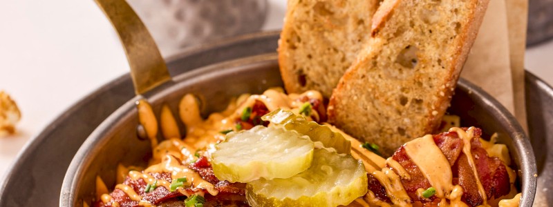 THE SLUGGER - Cheddar and mozzarella blend, Bullseye
bacon, ground beef patty, spicy pickles, and
Homerun sauce.