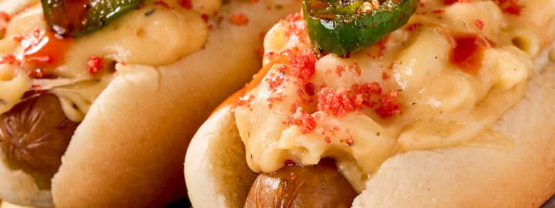 THE KNUCKLEBALL - Two jalapeno Cheddar dogs, pepper jack mac, grilled
jalapenos, Flamin Hot Cheeto dust, and hot sauce drizzle.