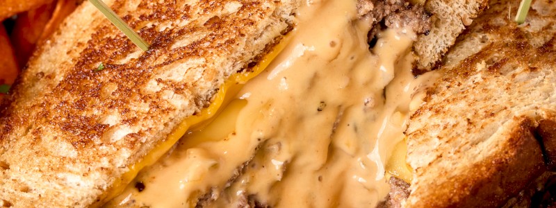 CBK SOURDOUGH GRILLED PATTY MELT - Two beef patties, grilled sourdough, sliced Gouda,
sharp Cheddar, and caramelized onions.