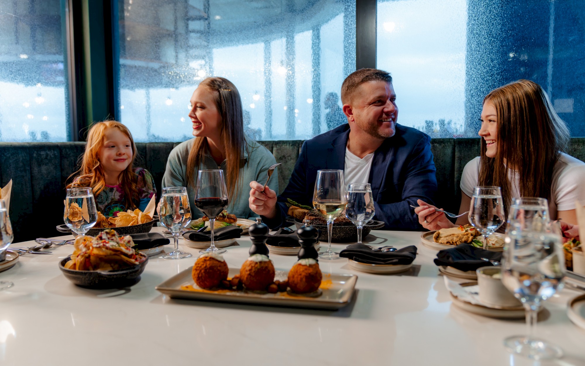 A family enjoys an upscale dinner at Jack Rabbit at OKANA Resort in OKC, featuring the elegant Jack Rabbit menu and a buffet breakfast each morning.