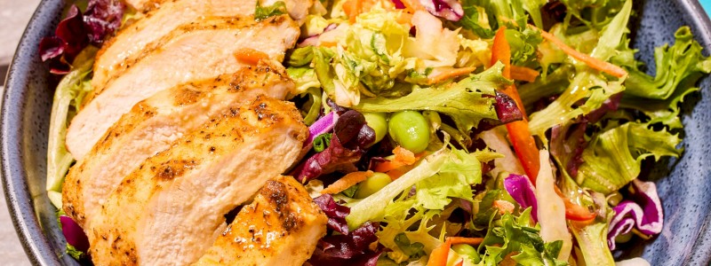 SESAME CHICKEN SALAD W/ GRILLED CHICKEN - Napa cabbage, baby greens, shredded carrots, green onions, and bell peppers