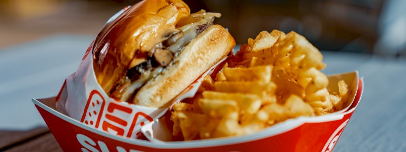 BOOMER SHROOMER - Single patty, sesame seed bun, mushrooms, provolone cheese, and caramelized onions, served with waffle fries