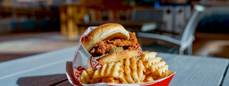 CHICKEN & PICKLE - Fried chicken breast, spicy pickles, and a brioche bun, served with waffle fries